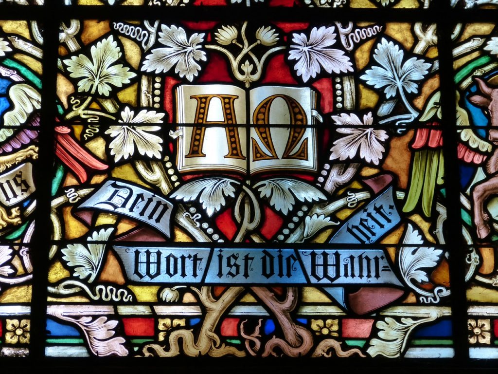 Kirchenfenster mit Weinblättern und den Schriftzürgen "Alpha-Omega" sowie "Dein Wort ist die Wahrheit"