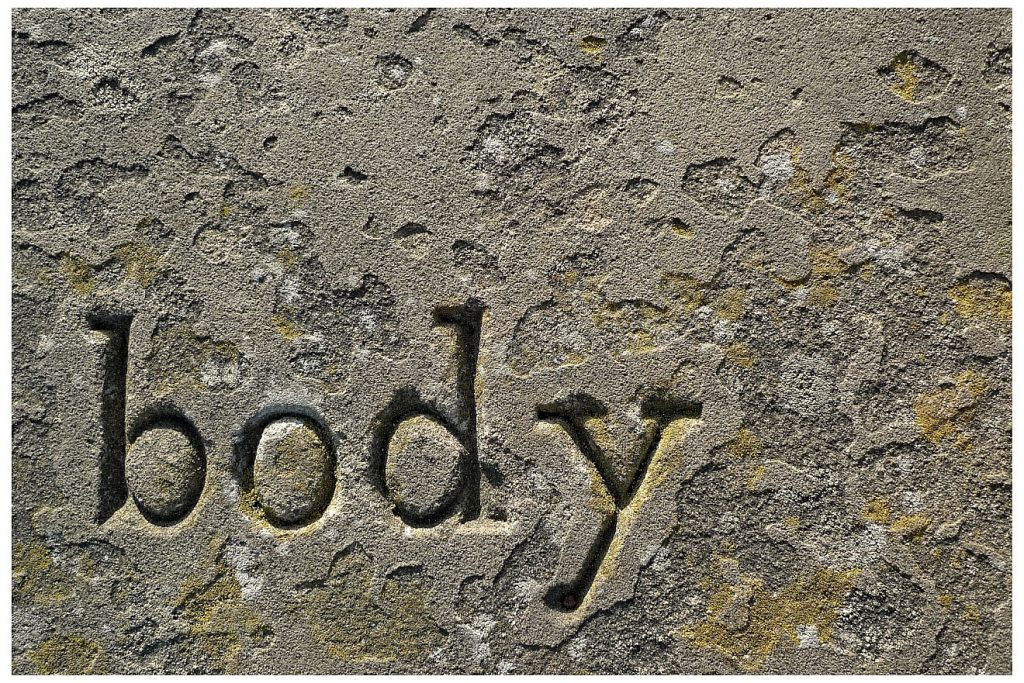 Glaubensstärke in schwerem Leid: Der Schriftzug "body" = "Körper" auf einem alten Grabstein