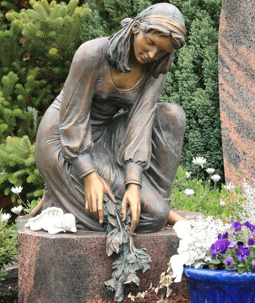 Gott nimmt Lasten von unserer Seele: Statue einer traurigen Frau, die Rosen auf ein Grab legt