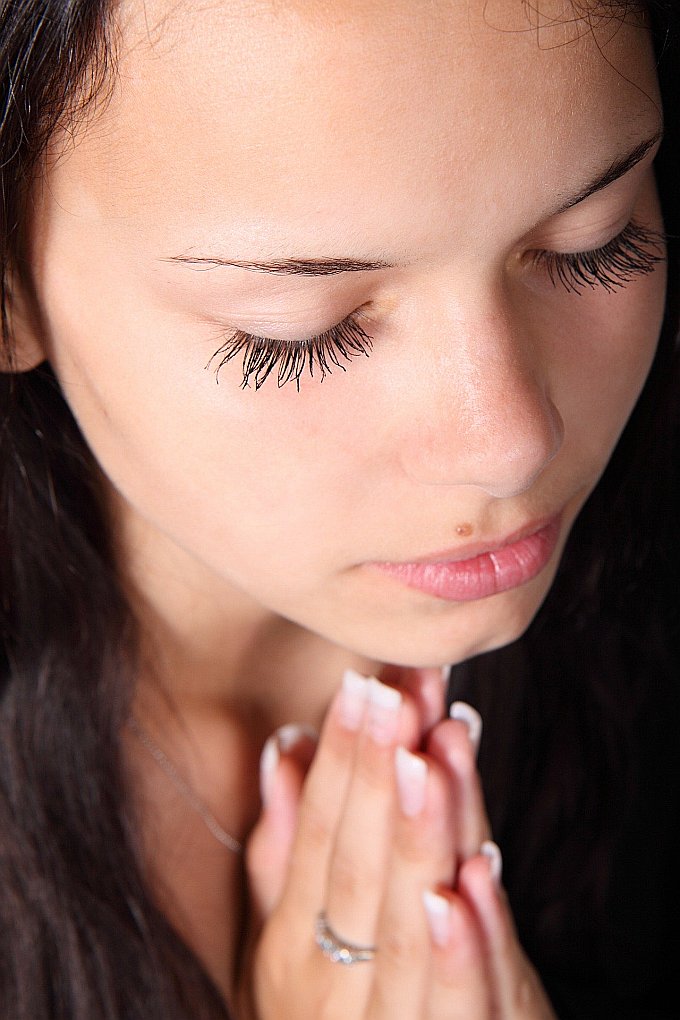 Eine betende Frau mit gefalteten Händen und niedergeschlagenen Augen - betet sie das Gebet des Jabez?