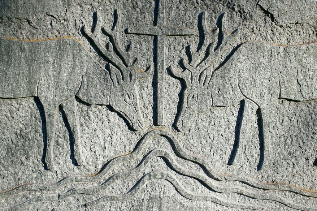 Relief von zwei Hirschen, die am Wasser trinken, über dem sich ein Kreuz erhebt