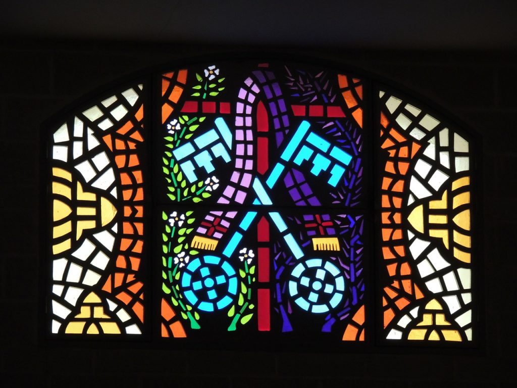Kirchenfenster mit einem Mosaik, auf dem zwei sich überkreuzende Schlüssel zu sehen sind