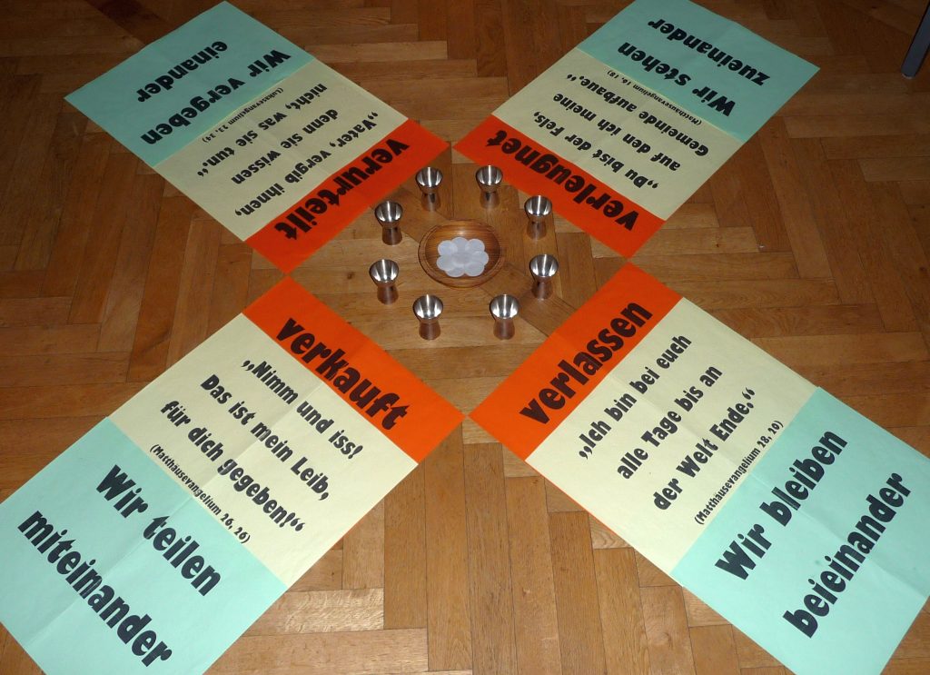 Gestaltung der Mitte des Konfi-Abendmahls mit Plakaten: verkauft, verlassen, verleugnet, verurteilt.