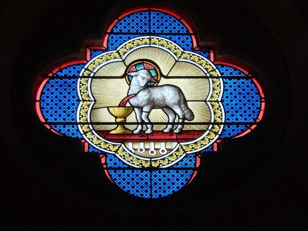 Das Lamm Gottes auf einem Kirchenfenster, dessen Blut in einen Kelch fließt