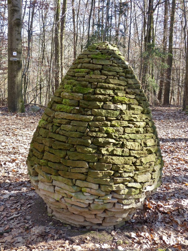 Ein riesiges aus Steinen aufgebautes Osterei im Wald