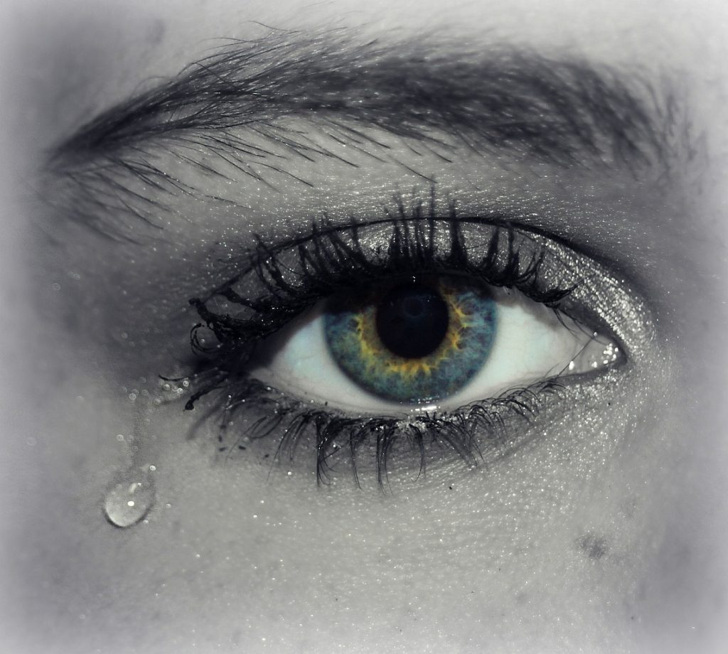 Geweinte Tränen abwischen: Ein Auge mit einer Träne im Augenwinkel
