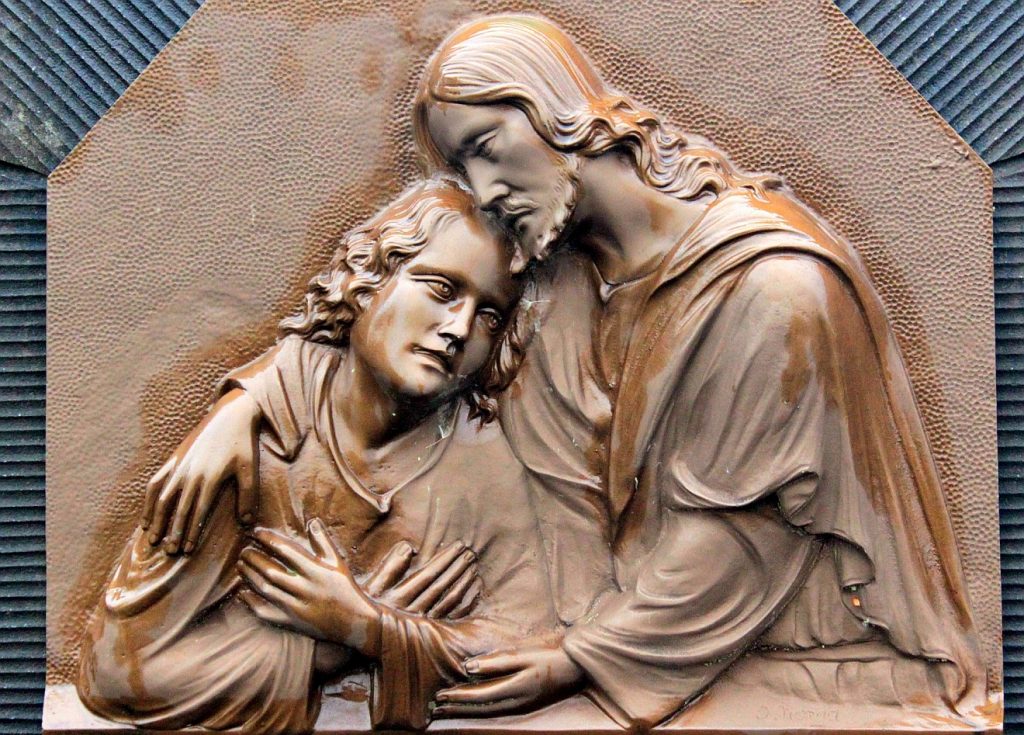 Er war kein Engel, aber er wird einer sein: Ein Relief mit Jesus, der einen Jungen in seine Arme schließt