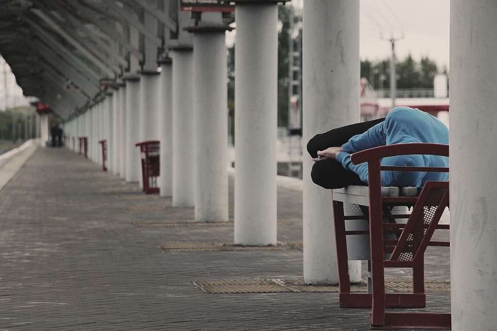 Menschen am Rand der Gesellschaft: Ein Mann schläft draußen auf einem Tisch unter einer Überdachung