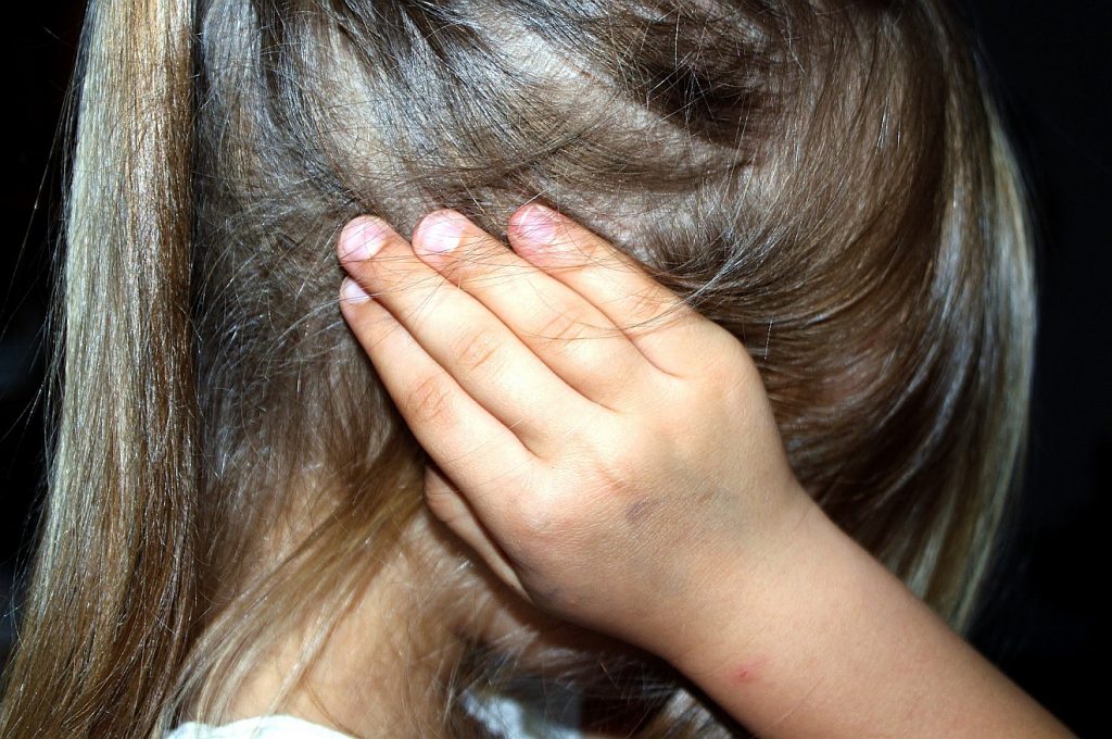 Die Missbrauchskrise kann eine Chance für die Kirche sein: Ein Mädchen versteckt sich hinter ihren Händen und Haaren