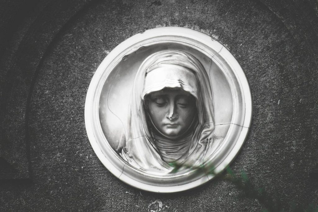 Maria mit Kopftuch und niedergeschlagenen Augen, dargestellt in einem Kreis